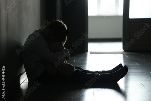 Cuadro en lienzo Upset little boy with toy bear near wall indoors