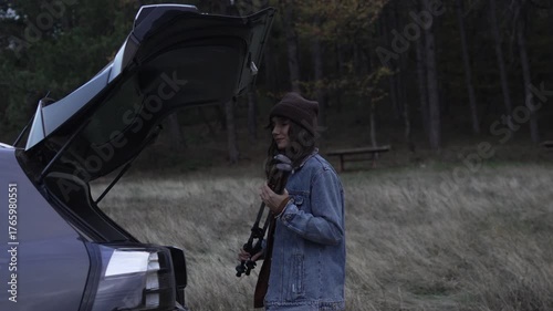 Couple unpacking car trunk for hiking trip in nature