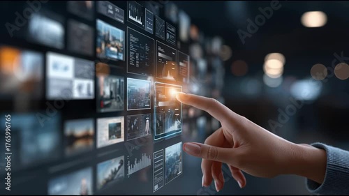 Futuristic technology showcased by hand and finger touching an interactive digital screen, selecting streaming video media from vast multimedia wall for on demand entertainment