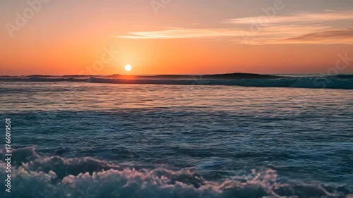 Waves crash on the shore as the sun sets over the ocean horizon view