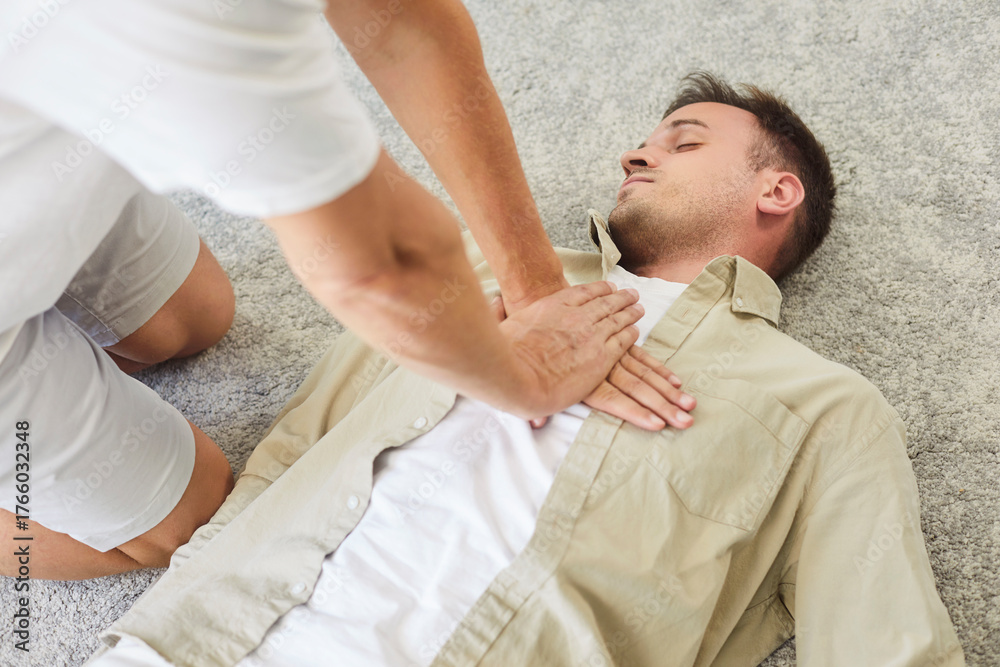 Fototapeta premium CPR chest compressions assist patient in emergency resuscitation. Hands press the chest of an unresponsive unconscious man. A rescuer gives first aid to patient. Lifesaving skills concept.
