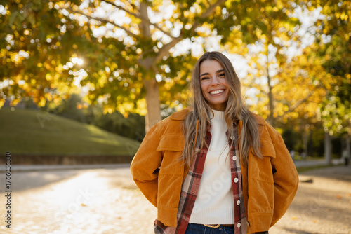 young beautiful blond woman walking in autumn park, stylish , smiling, happy, trendy season warm outfit, wearing velvet terracotta color jacket