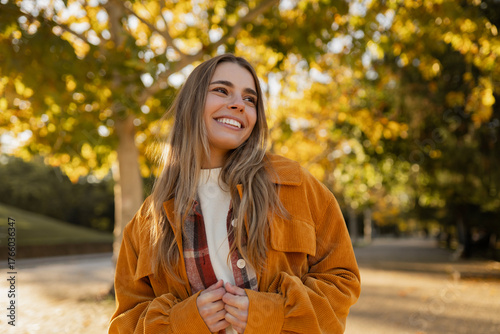 young beautiful blond woman walking in autumn park, stylish , smiling, happy, trendy season warm outfit, wearing velvet terracotta color jacket