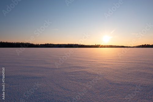 Winter Sunset over Frozen Lake with Snow Surface