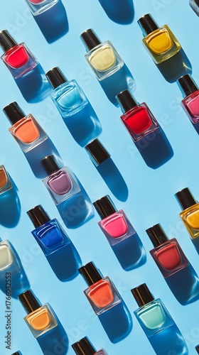 Colorful Nail Polish Bottles Arranged in a Creative Flat Lay on a Bright Blue...