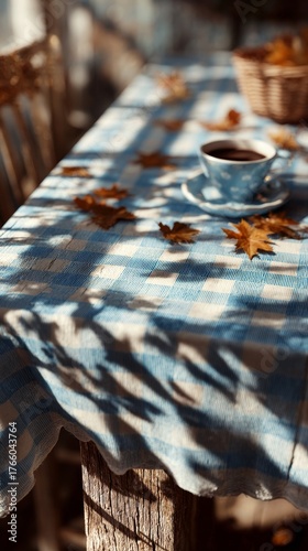 Coffee on a Blue Checkered Table With Fallen Leaves in a Cozy Autumn Setting