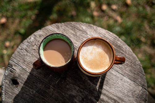 Two Coffee Cups on a Wooden Table in a Calm Outdoor Setting During Daytime