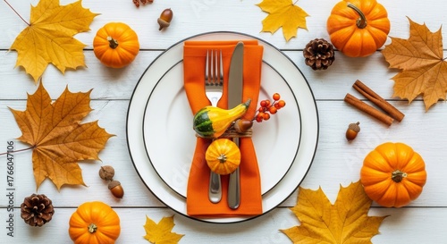 Festive Thanksgiving table setting with pumpkins, leaves, and acorns arranged around a plate with cutlery.