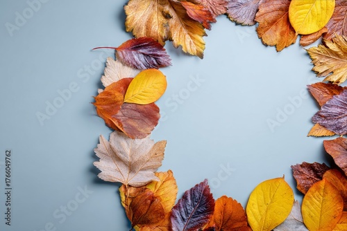 Colorful Autumn Leaves Arranged in a Circle on a Light Blue Background