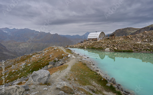 The Vittorio Emanuele II refuge and Montecorve lake in Graian Alps in the heart of the Gran Paradiso National Park, Italy. A starting point for climbing mount Gran Paradiso. Rain clouds in the sky. 