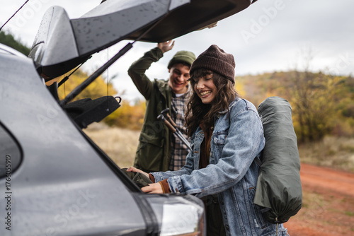 Εκτύπωση καμβά Couple preparing hiking gear from car trunk for fall adventure