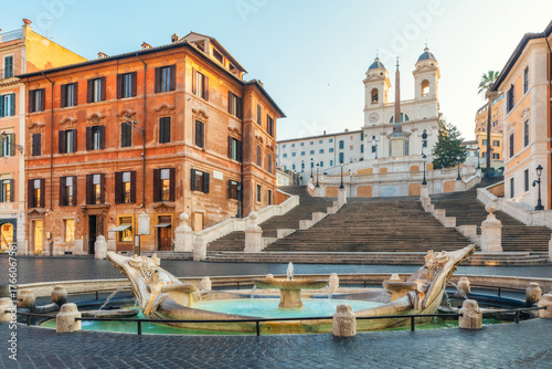 Tableau sur toile Spanish Steps with Trinita dei Monti church and Fontana della Barcaccia fountain at sunrise and historic buildings in old town of Rome city, Italy
