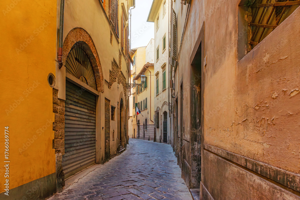 Obraz premium Old narrow street with rustic buildings and cobblestone pavement in Florence city, Tuscany, Italy. Firenze old town. Italian architecture