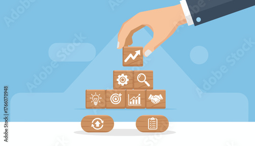 Hand arranging wooden blocks with business strategy icons, symbolizing growth, planning, and collaboration, representing successful business development and teamwork in a modern corporate environment.