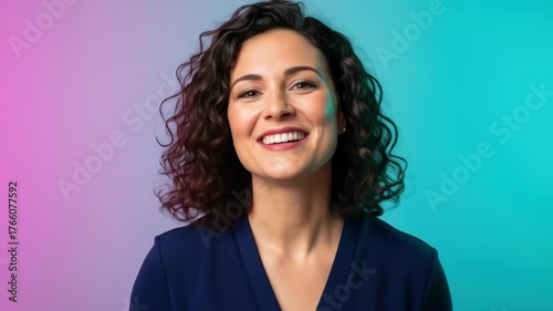 Vibrant portrait of a smiling woman with curly hair pointing forward on a neon background