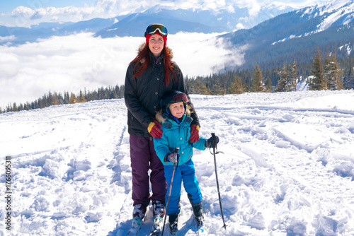 Young sporty woman having fun skiing with kid boy with ski on mountains alpine winter resort.Mother little son child family enjoy extreme sport activities recreation