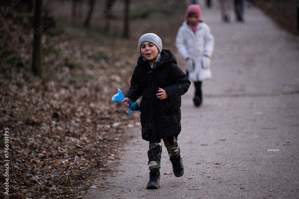 Fototapeta premium Young boy running outdoors playing with toy