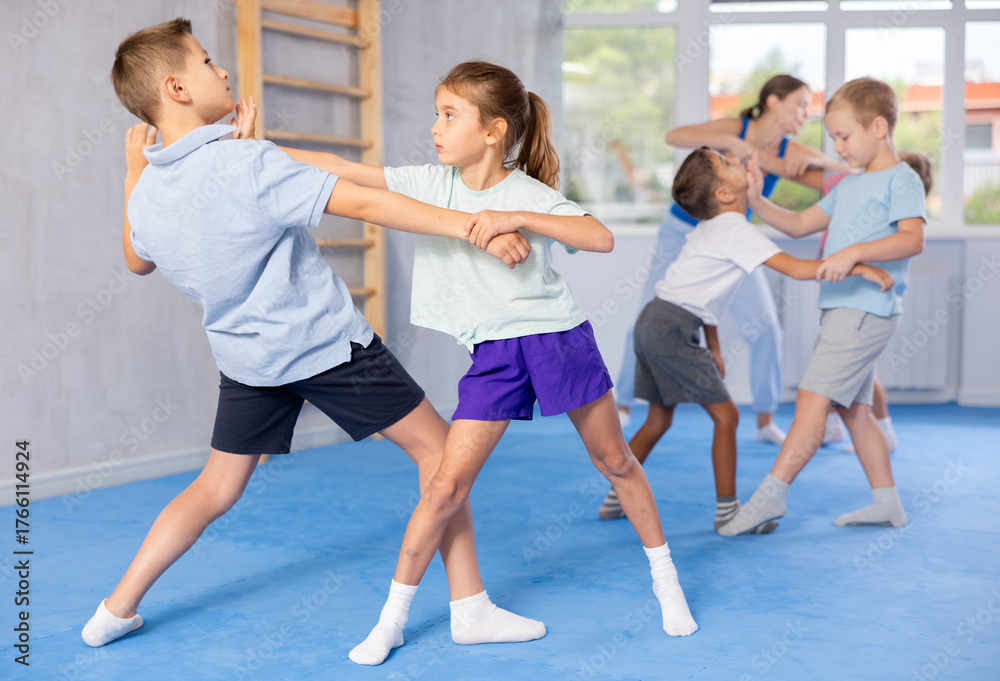Obraz premium Young fighters in gym focus intensely on perfecting their head punch technique.