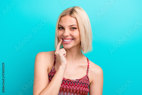 Foto Smiling young woman with blonde bob wearing a patterned tank top against a turqu