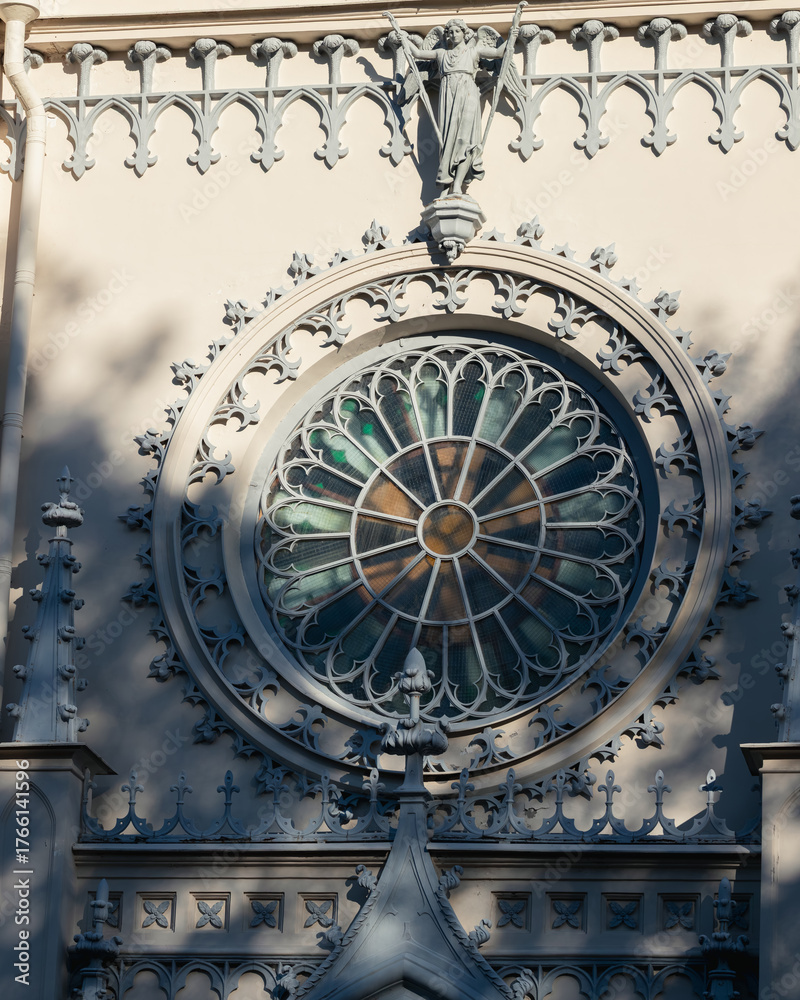 Fototapeta premium Close-up of the ornate stained glass rose window and decorative stone details on the Gothic Chapel facade in Alexandria Park, Peterhof.