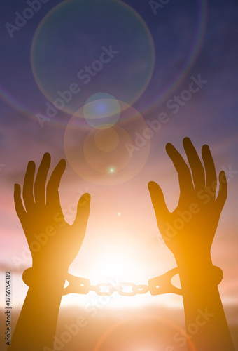 Freedom and liberation concept with broken chain silhouette at sunrise