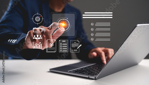 A person interacts with a laptop, using touch input to engage with digital icons and data displays, showcasing technology and modern business practices.