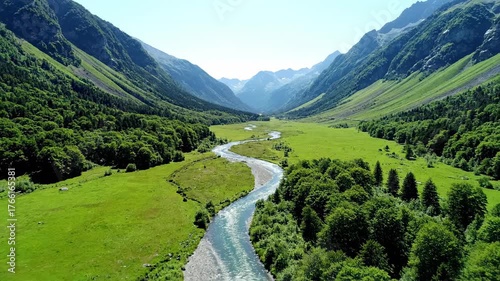 A magnificent sweeping aerial drone shot showcasing a winding river gracefully flowing through a vast, pristine green mountain valley elevated, landscape, beauty