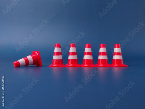 The image shows several miniature traffic cones, with one lying on its side