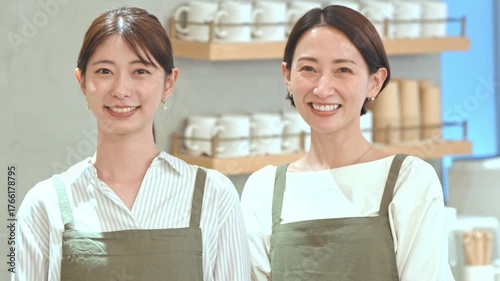 カフェに立つ笑顔のエプロンをつけた女性