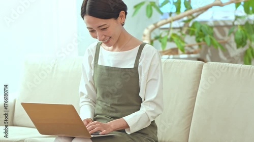 ソファに座り仕事をする女性
