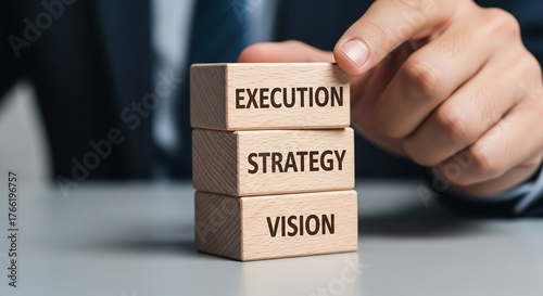 A stack of wooden blocks with VISION, STRATEGY, and EXECUTION, representing the core hierarchy of successful business leadership and project management flow.