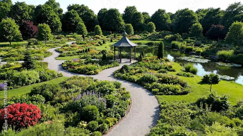 An expansive aerial drone shot gracefully sweeping over a meticulously landscaped botanical garden showcasing diverse plant arrangements tranquility, meticulously, vista