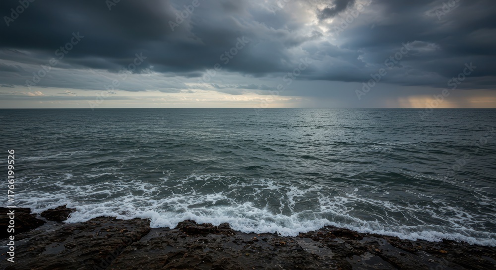 Obraz premium Expansive maritime view of the powerful ocean merging with the distant horizon under a dramatic, cloudy sky, evoking solitude and escape ,escape ,destination ,blue