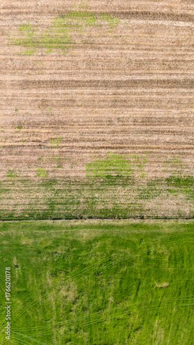 A beautiful vertical top down shot of an agricultural field split between a lush green pasture and a freshly plowed area