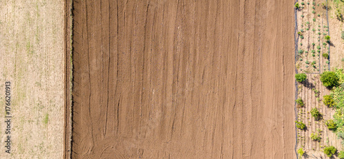 A top down aerial shot of a freshly plowed field next to a harvested field creating a beautiful natural background of lines and textures