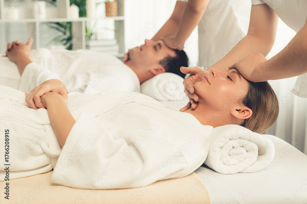 Obraz premium Caucasian couple enjoying relaxing anti-stress head massage and pampering facial beauty skin recreation leisure in dayspa modern light ambient at luxury resort or hotel spa salon. Quiescent