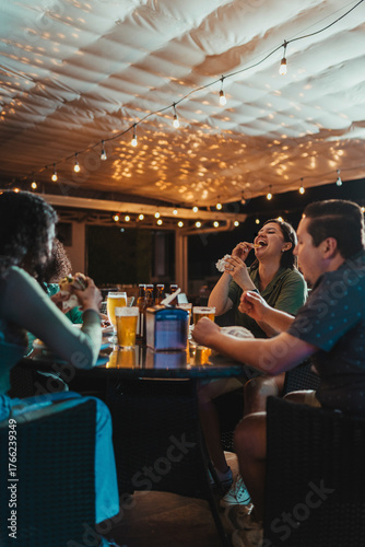 Foto Group of friends enjoying burgers and beers at an outdoor restaurant during the evening