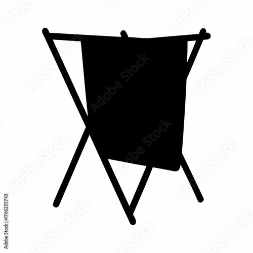 Silhouette of a portable clothes drying rack with draped laundry item
