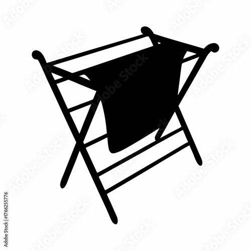 Silhouette of a folding clothes drying rack with a towel draped over it