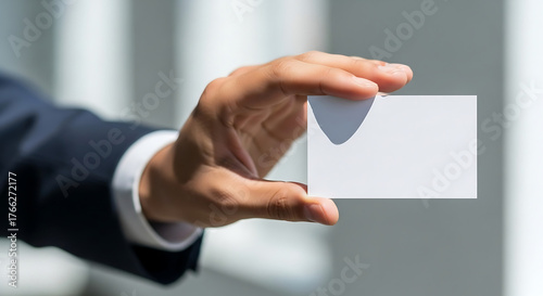 Hand holding a blank business card for networking.