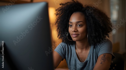 Focused young woman working on a computer at home in the evening, surrounded by warm ambient light and bookshelves, representing concentration, technology, remote work, and modern professional lifesty