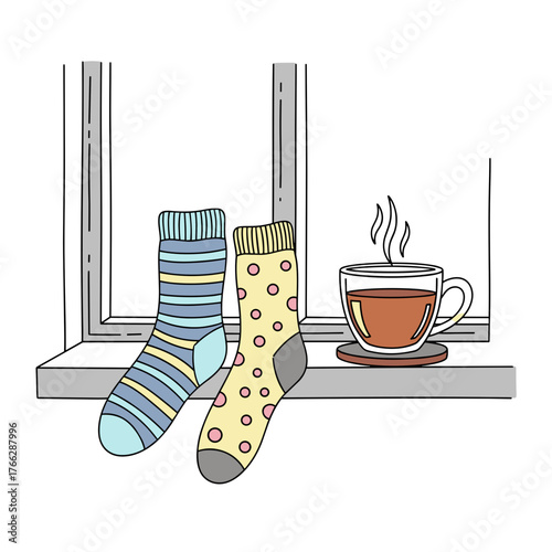 Colorful socks resting on windowsill beside a steaming cup of tea  