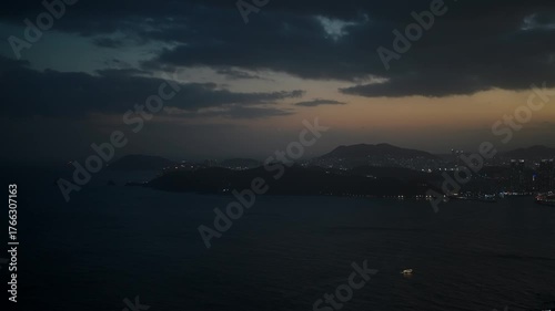 Busan cityscape revealing illuminated buildings and ocean reflecting the dimming sky at dusk