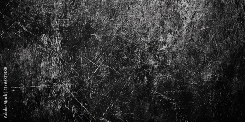 A wall textured surface by a deep gray color with varying shades scuffs, and a mottled, worn out appearance.