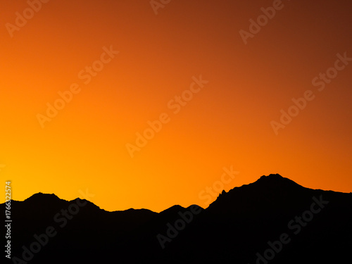八ヶ岳の赤岳を染めるオレンジ色の夕暮れ空と雄大な山々の風景