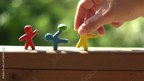 Wallpaper Mural Hand placing a yellow clay figure into a line with others Torontodigital.ca