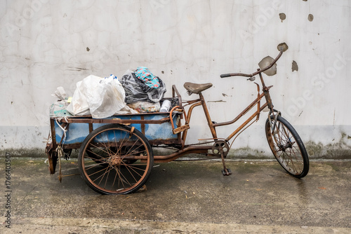 Chinese Three Wheeled Delivery Bicycle. An old Chinese cargo tricycle used for deliveries with pedals and electric motor