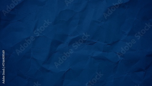 Crumpled dark blue paper background with wavy surface texture. Abstract blue paper texture for modern design. Wrinkled paper background with copy space for text.