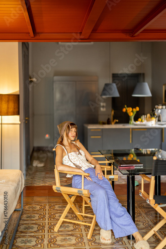 Woman relaxing in a stylish Sicilian apartment with vintage tiles, cozy decor, and warm Mediterranean light. Concept of slow living and peaceful home life