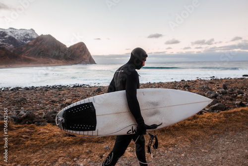 Cold Water Surfer Walking with Board by Arctic Ocean